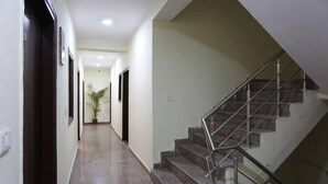 A hallway with a staircase leading to an upper floor. - Hotel Airport Sinon by Dream Laxmi (New Delhi)