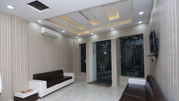 A modern living room with a sofa, a coffee table, and a TV mounted on the wall. - Hotel Airport Sinon by Dream Laxmi (New Delhi)