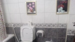 Ein Badezimmer mit Toilette, Bidet und einer kleinen Ablage mit Dekoration.