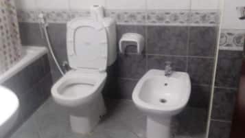 Combined shower/bathtub, slippers, towels, soap