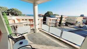 A balcony with a view of a residential area, including a swimming pool and parked cars. - 3-room new apartment,  5-min walk to 3 sandy beaches  (Topola Village)