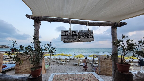 A beachside patio with a rustic wooden pergola, a patterned rug, and potted plants. - 3-room new apartment,  5-min walk to 3 sandy beaches  (Topola Village)