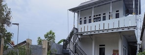 A two-story building with a balcony and a staircase. - Hotel O Penginapan Al-asharNearWarung Acil Ubai (Boemirata)