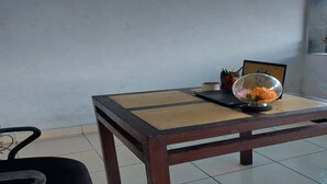 A wooden table with a glass dome containing flowers, a framed picture, and a small container with pens and pencils. - Hotel O Penginapan Al-asharNearWarung Acil Ubai (Boemirata)