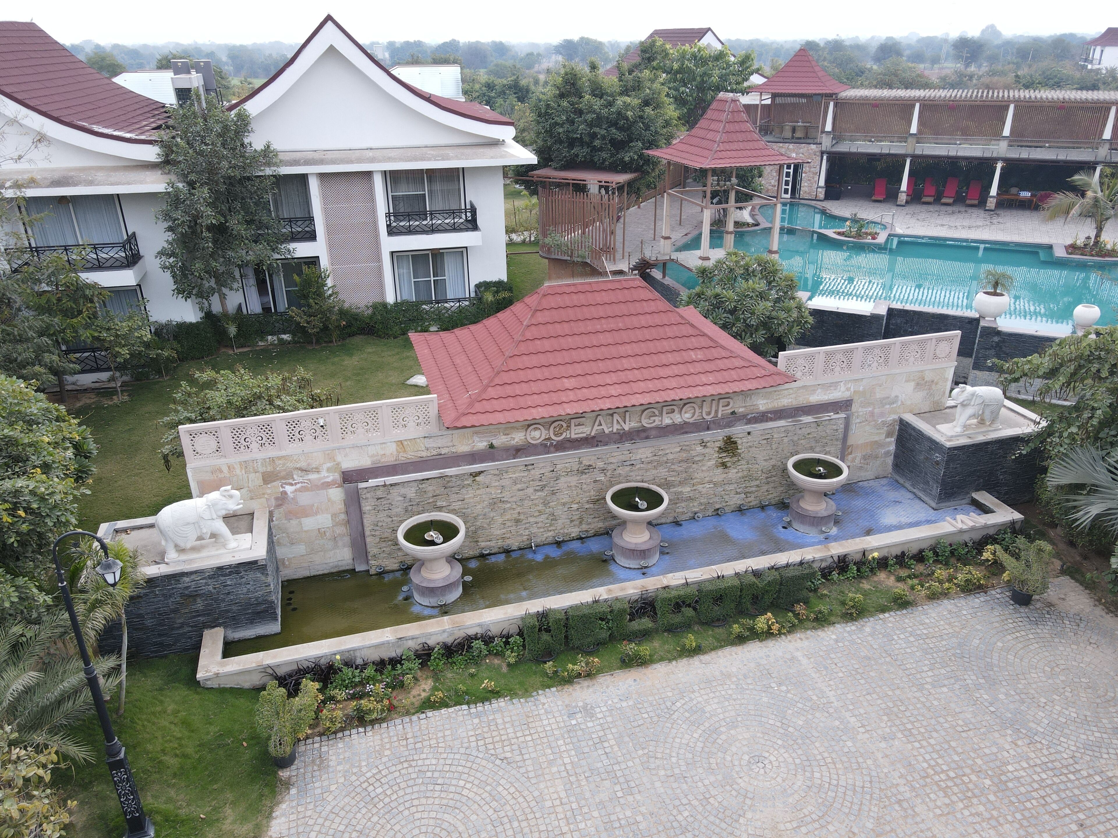 Um resort com piscina, fonte e uma estátua de elefante.