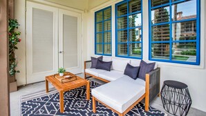 A room with a sofa, a wooden table, and a patterned rug. - Rancho Sol A | 1BR Legacy Villa (La Quinta)