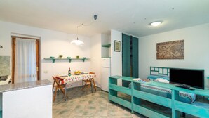 Ein kompakter Wohnraum mit Küche, Essbereich und TV-Ecke.