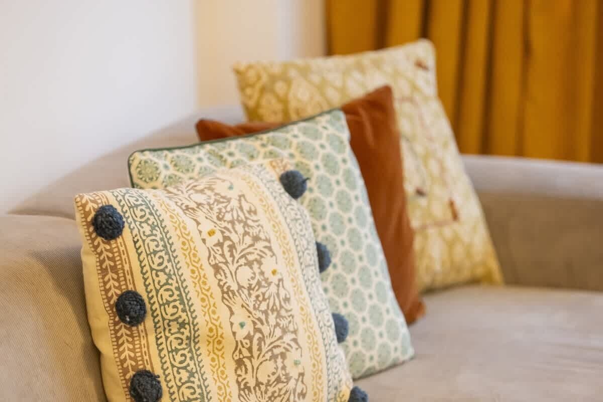 Un canapé avec des coussins à motifs et un oreiller marron.