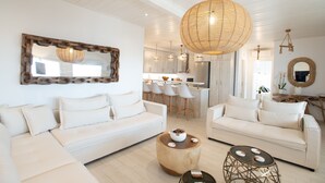 A modern living room with a sofa, coffee table, and pendant lighting. - TIFFANYS VILLAS (Mykonos)