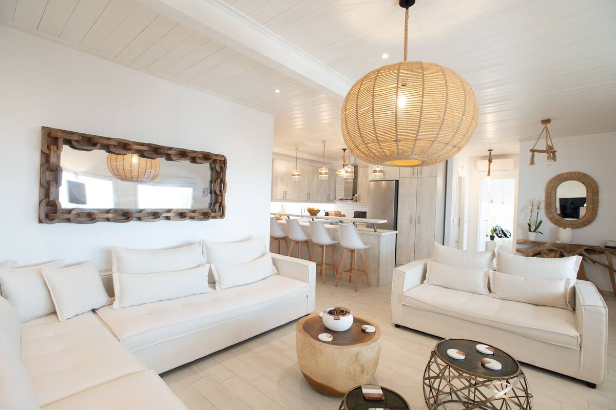 A modern living room with a sofa, coffee table, and pendant lighting.