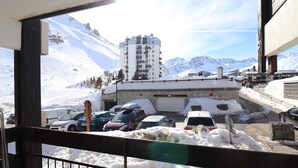 Vista nevada de una montaña con un área de estacionamiento y un edificio de varios pisos.