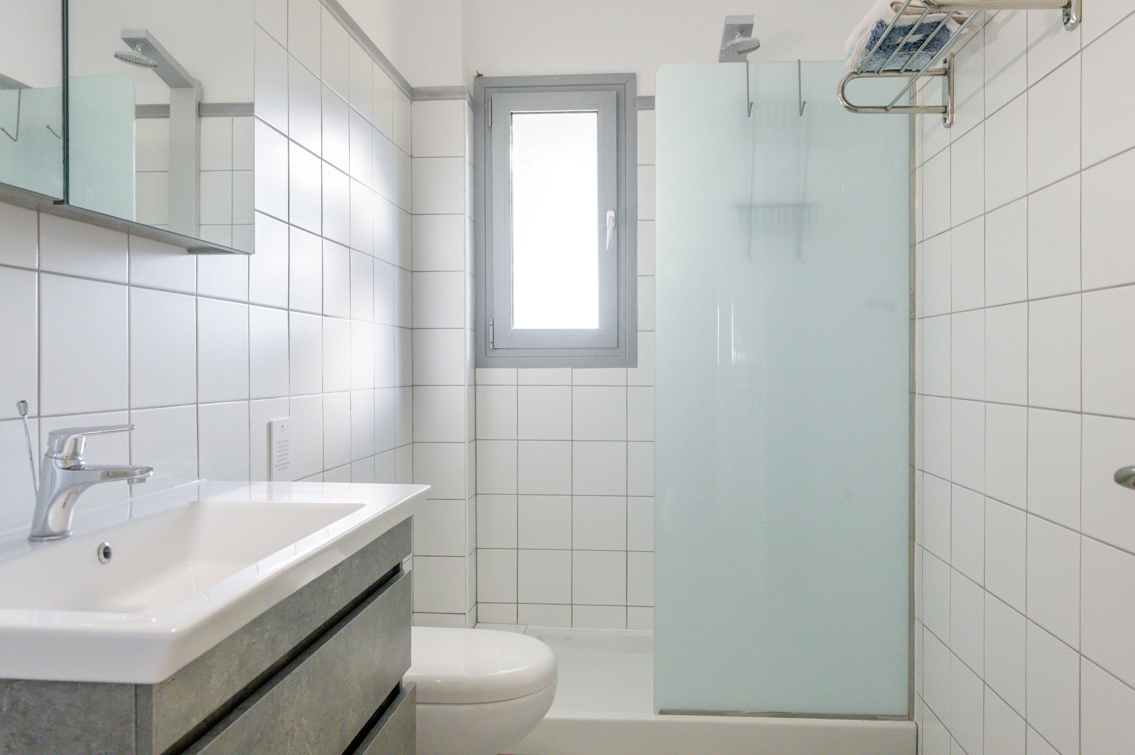 Une salle de bain équipée d’un lavabo, de toilettes et d’une douche à parois en verre.