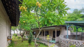 A house with a covered porch and a stone wall.