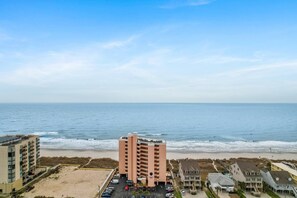 A beachfront hotel with multiple floors, a parking lot, and a view of the ocean. - Oceanfront at Carolina Reef w/ Pools, 2 Bds (North Myrtle Beach)