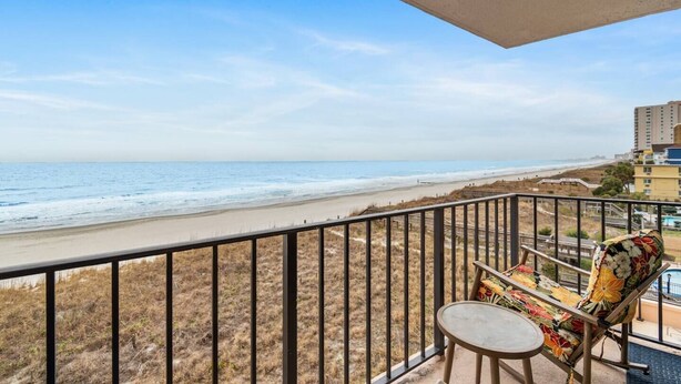 Ein Balkon mit Blick auf Strand und Meer.