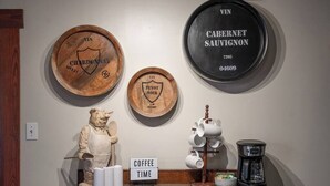 Una estación de café con un cartel que dice 'COFFEE TIME', una cafetera y una figurita de oso.