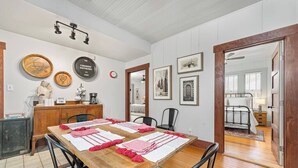 Un comedor con mesa de madera, sillas y una estación de café.