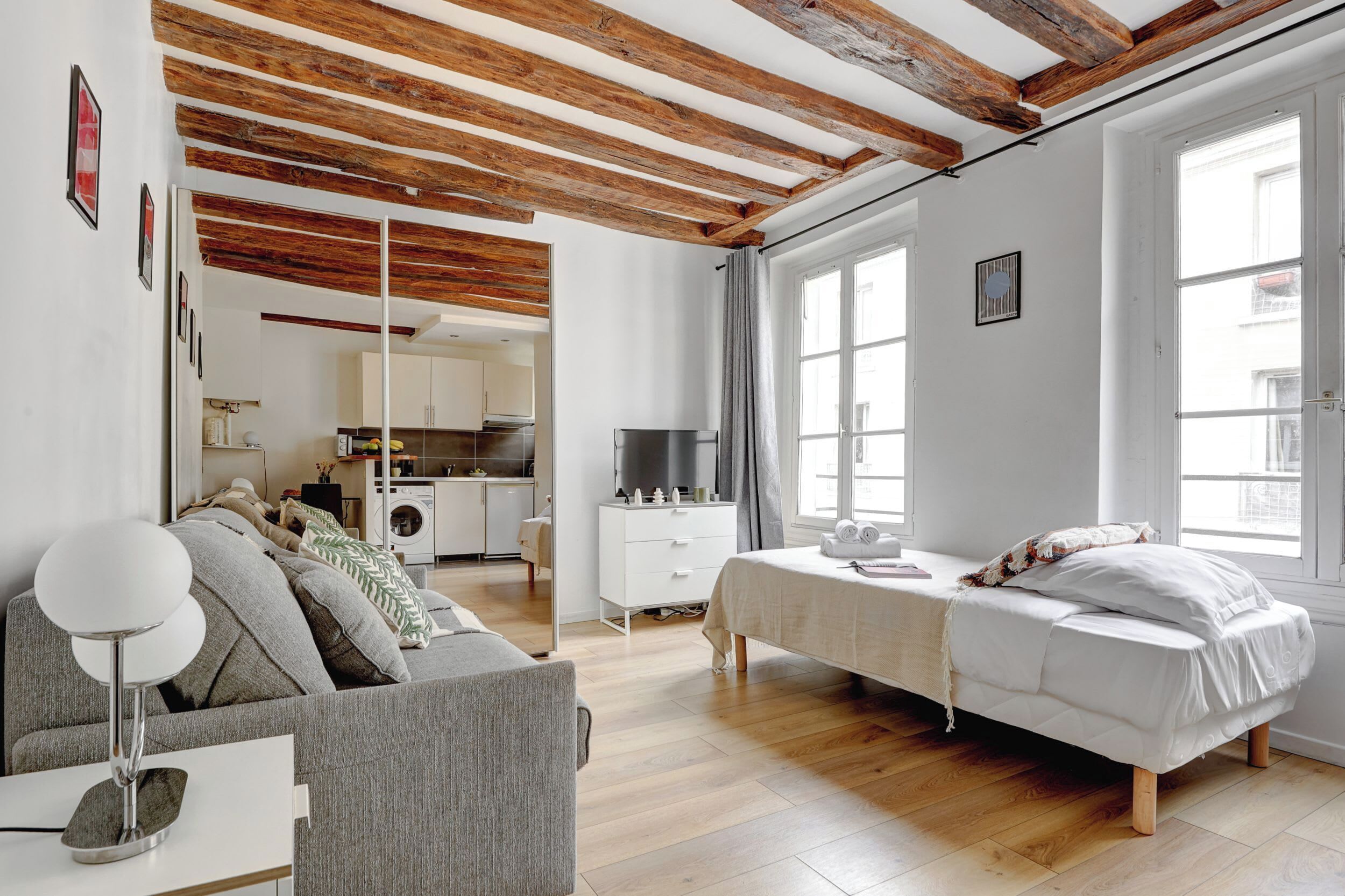 Una camera da letto moderna con soffitto in legno, un letto, un divano e una TV.