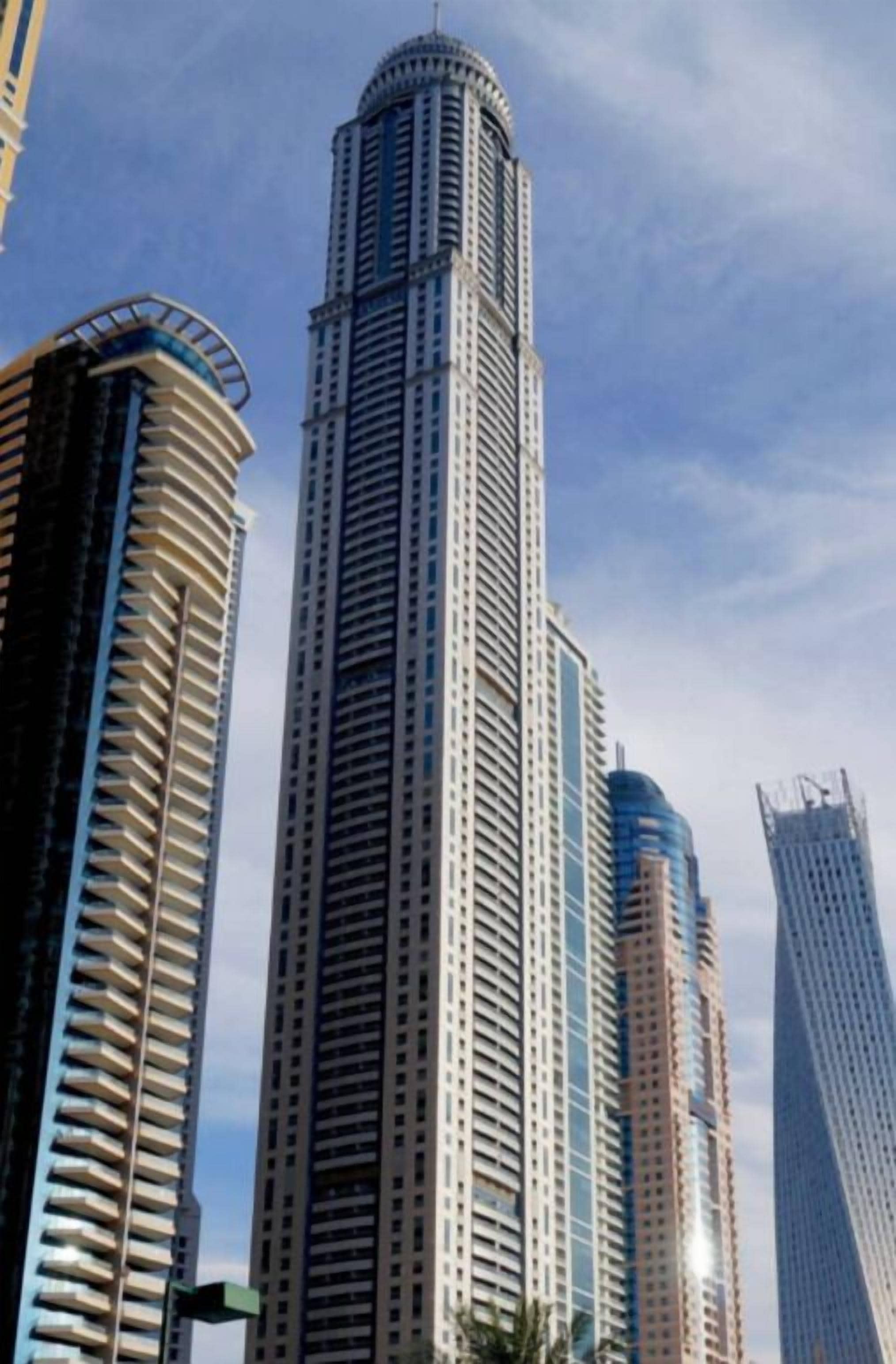 Un edificio de gran altura con una torre central cilíndrica, rodeado de otras estructuras elevadas.