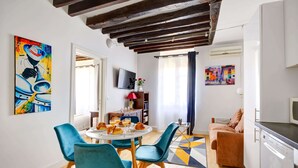 A modern living space with a dining area, kitchen, and seating area.