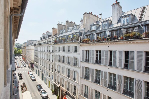 A row of white buildings with multiple stories, each with balconies and windows.