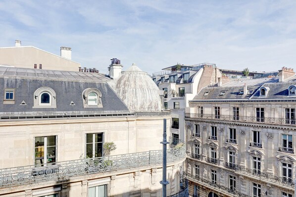 A multi-story building with classical architecture, featuring ornate balconies and a prominent dome structure.