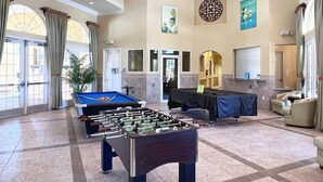 Un vestíbulo amplio con mesa de fútbol, asientos cómodos y mesa de billar.