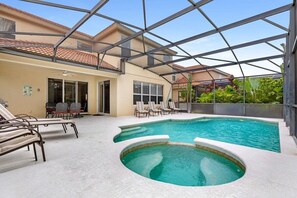 Une piscine avec des chaises longues et un patio couvert.