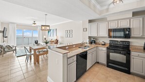 A modern kitchen with a central island, a dishwasher, an oven, and a microwave. - Beachfront-Pool-Balcony-Wonderful View (Gulf Shores)