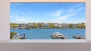 A marina with modern houses, boats, and a clear blue sky.