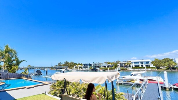 A pool area with a view of a marina and modern buildings.