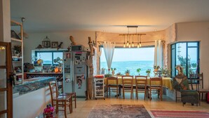 A kitchen with a view of the sea, wooden furniture, and various decorative items. - Loveneel Sea Galilee Retreat by SeaNRent (Yavne'el)