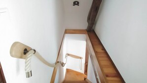 A wooden staircase with a handrail and a light fixture on the wall. - Maison de Caractère, Jardin Clos , au Calme, Proche zoo de Beauval et Châteaux (Écueillé)