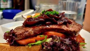 Sándwich de carne y verduras acompañado de papas fritas en un plato.