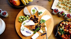 A cheese board with various cheeses, grapes, and nuts.