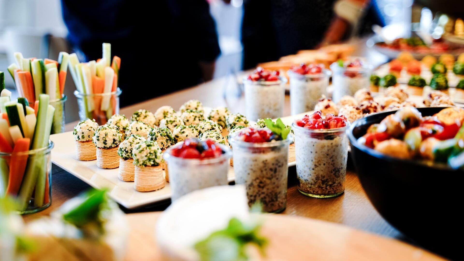 A buffet table with various food items including appetizers, desserts, and beverages.