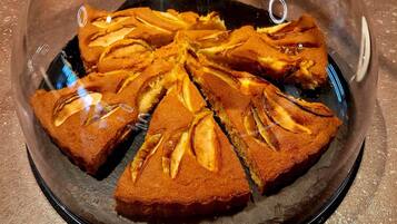 A cake with a glass dome on a black plate.