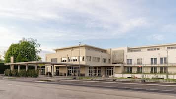 A modern building with a covered entrance, multiple windows, and a flat roof.