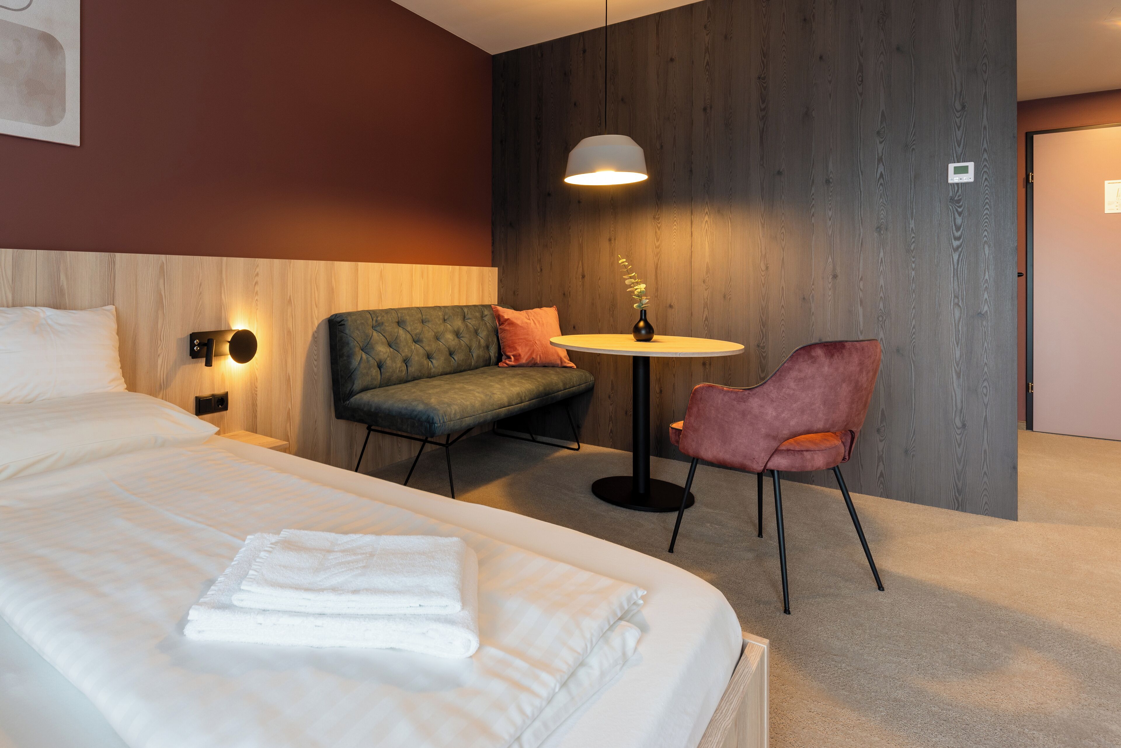 Een hotelkamer met een groot bed, een bank, een bijzettafeltje en een stoel.
