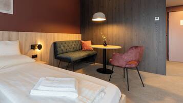 Een hotelkamer met een groot bed, een bank, een bijzettafeltje en een stoel.