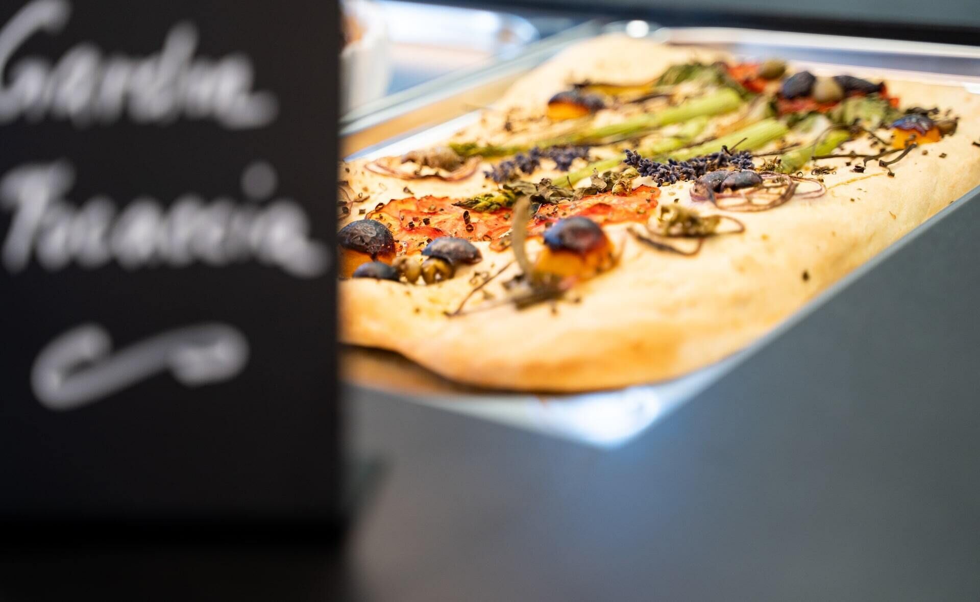 A pizza with various toppings on a tray.