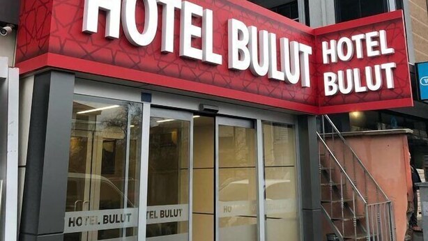 Un letrero de hotel con el nombre 'HOTEL BULUT' en letras blancas grandes sobre un fondo rojo.