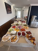 Una mesa de buffet con diversos platos y una zona de cocina al fondo.
