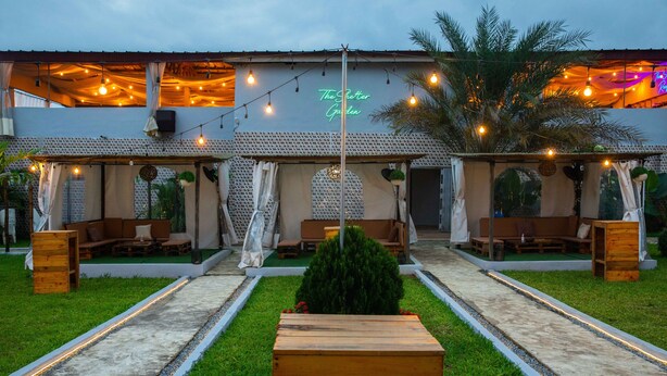 A garden with outdoor seating and string lights. - The SHELTER (Abidjan)