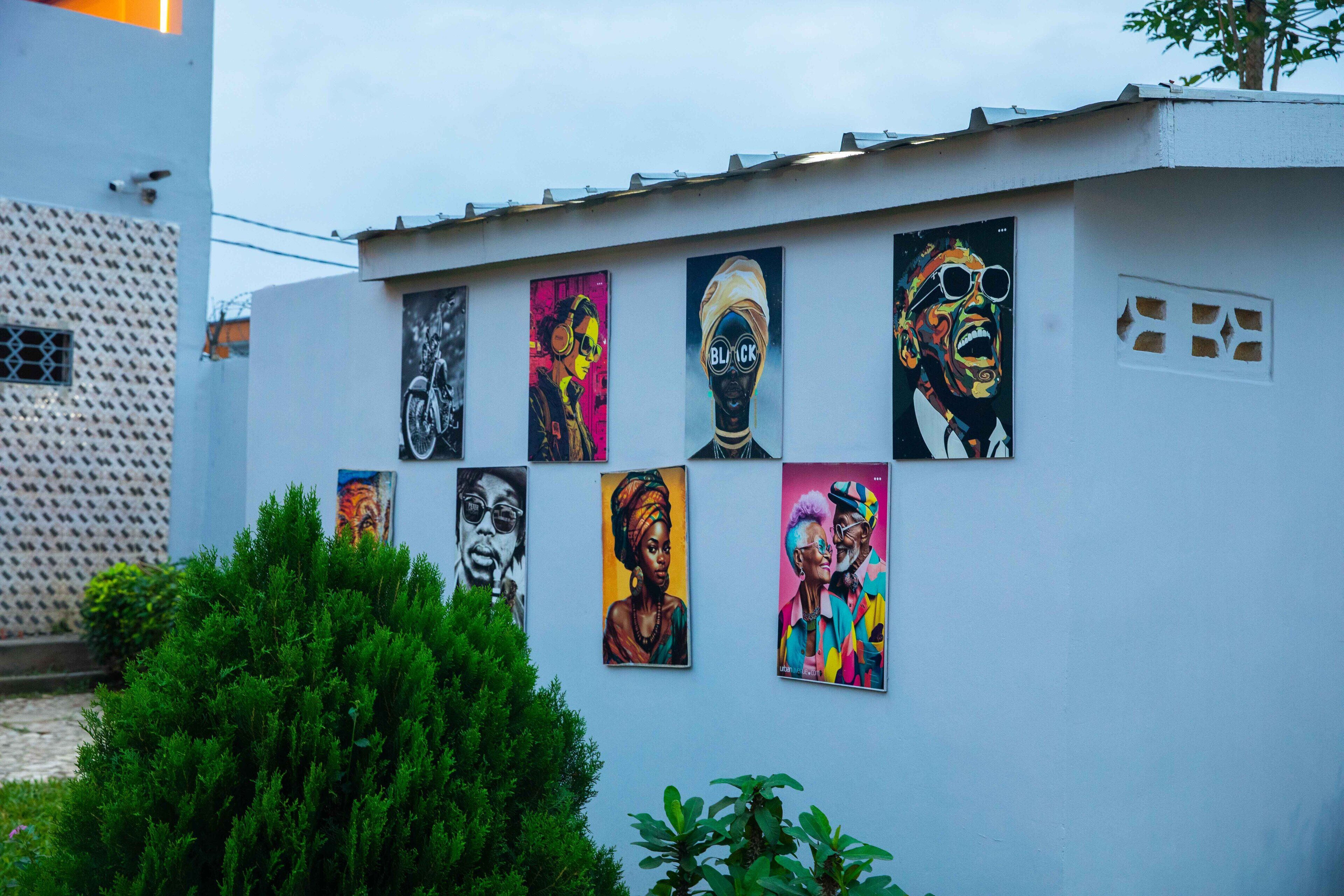 A building with a white exterior and a series of colorful murals on its side.