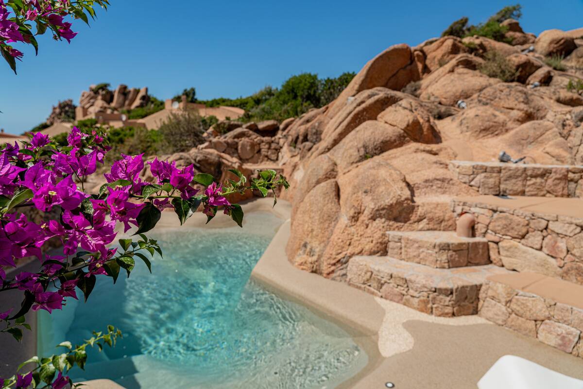 A pool surrounded by stone steps and natural rock formations.
