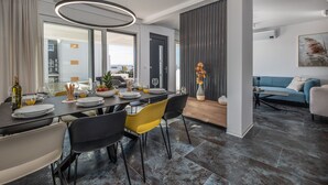 A modern dining area with a dark wooden table, yellow chairs, and a vase of flowers.