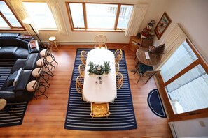 A dining area with a table set for four, surrounded by chairs, a sofa, and a small stool. - Pet Friendly Private Waterfront home, Estates (Campton)