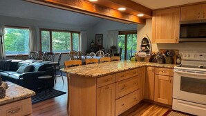 A kitchen with wooden cabinets, granite countertops, a built-in oven, and a dining area with a table and chairs. - Pet Friendly Private Waterfront home, Estates (Campton)
