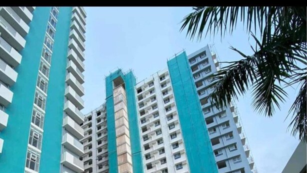 A poolside area with lounge chairs and a swimming pool, surrounded by high-rise buildings with blue accents. - Oceanview Studio Bacolod City (Bacolod)